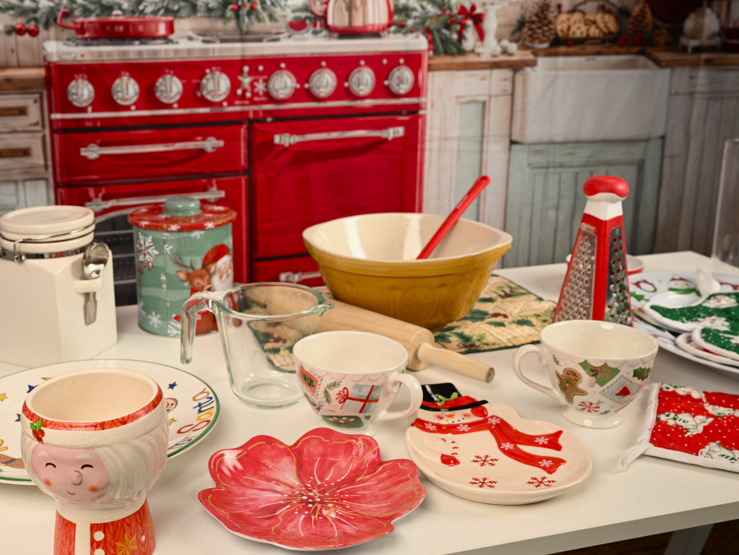 Decorative kitchen scene with red oven, Christmas-themed tableware, and festive decorations.