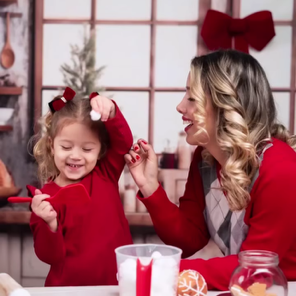 Woman and child in red outfits with Christmas decorations